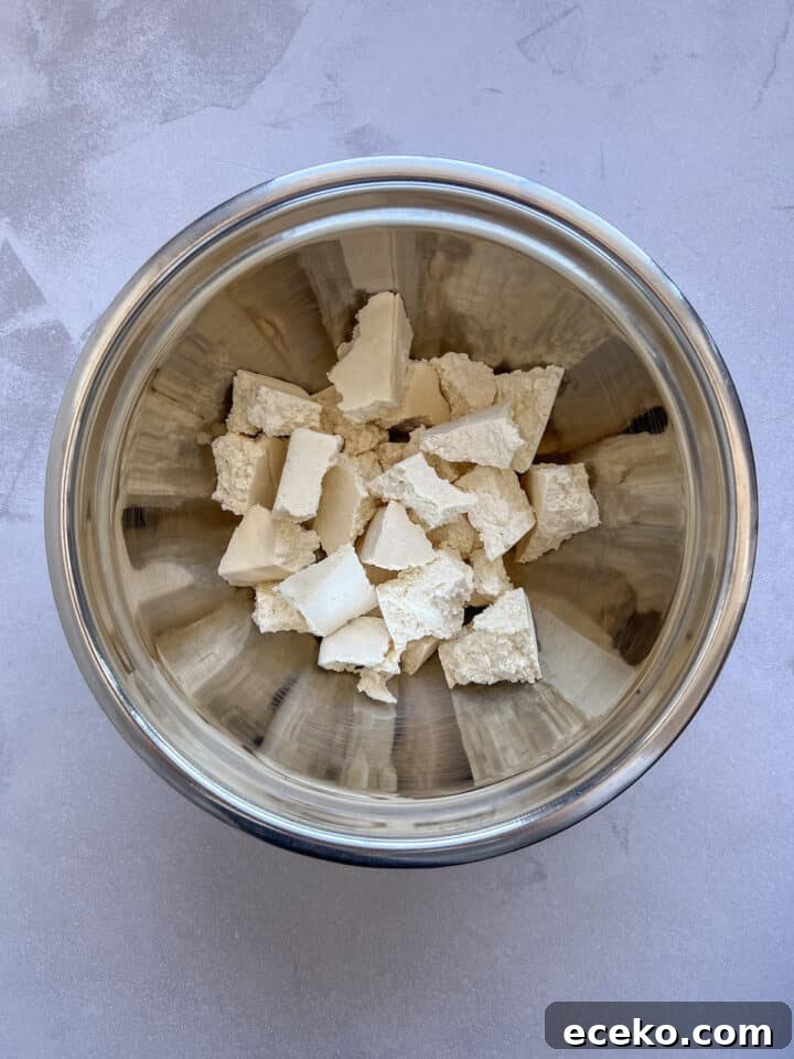 Crispy Air Fryer Tofu Nuggets — Quick Weeknight Recipe 6 Raw tofu chunks in a large silver mixing bowl