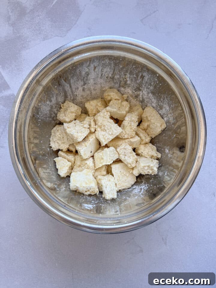Crispy Air Fryer Tofu Nuggets — Quick Weeknight Recipe 8 Tofu mixed with corn starch, oil, and seasonings in a large silver mixing bowl