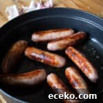 Cowboy Stew Recipes: Campfire, Stovetop, Oven & Slow Cooker Methods 18 8 browned sausages in a black cast iron pan