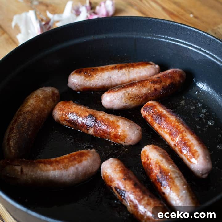 Cowboy Stew Recipes: Campfire, Stovetop, Oven & Slow Cooker Methods 3 8 browned sausages in a black cast iron pan