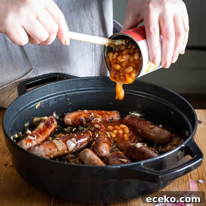 Cowboy Stew Recipes: Campfire, Stovetop, Oven & Slow Cooker Methods 7 womans hands spooning baked beans from a can into a pan of sausages for a campfire stew