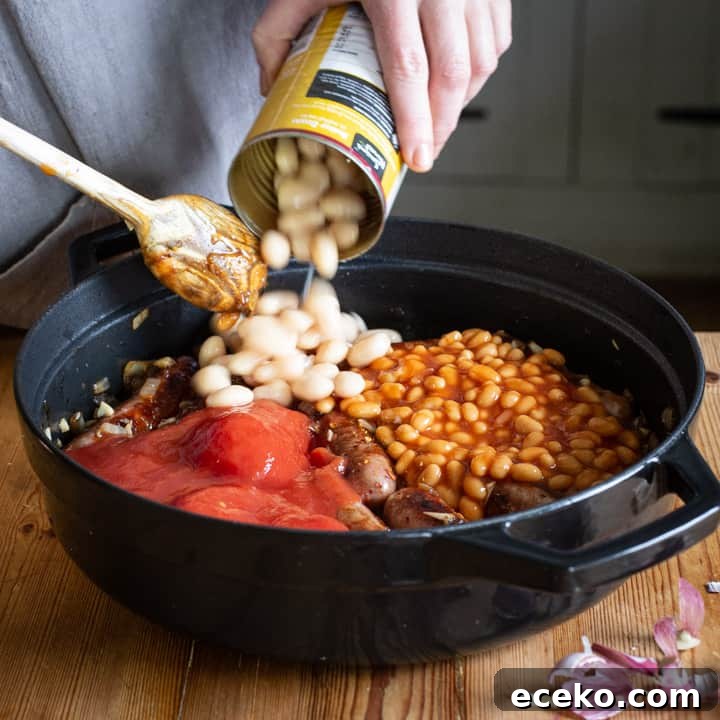 Cowboy Stew Recipes: Campfire, Stovetop, Oven & Slow Cooker Methods 9 womans hands tipping a can of butter beans into a pan of homemade sausage casserole