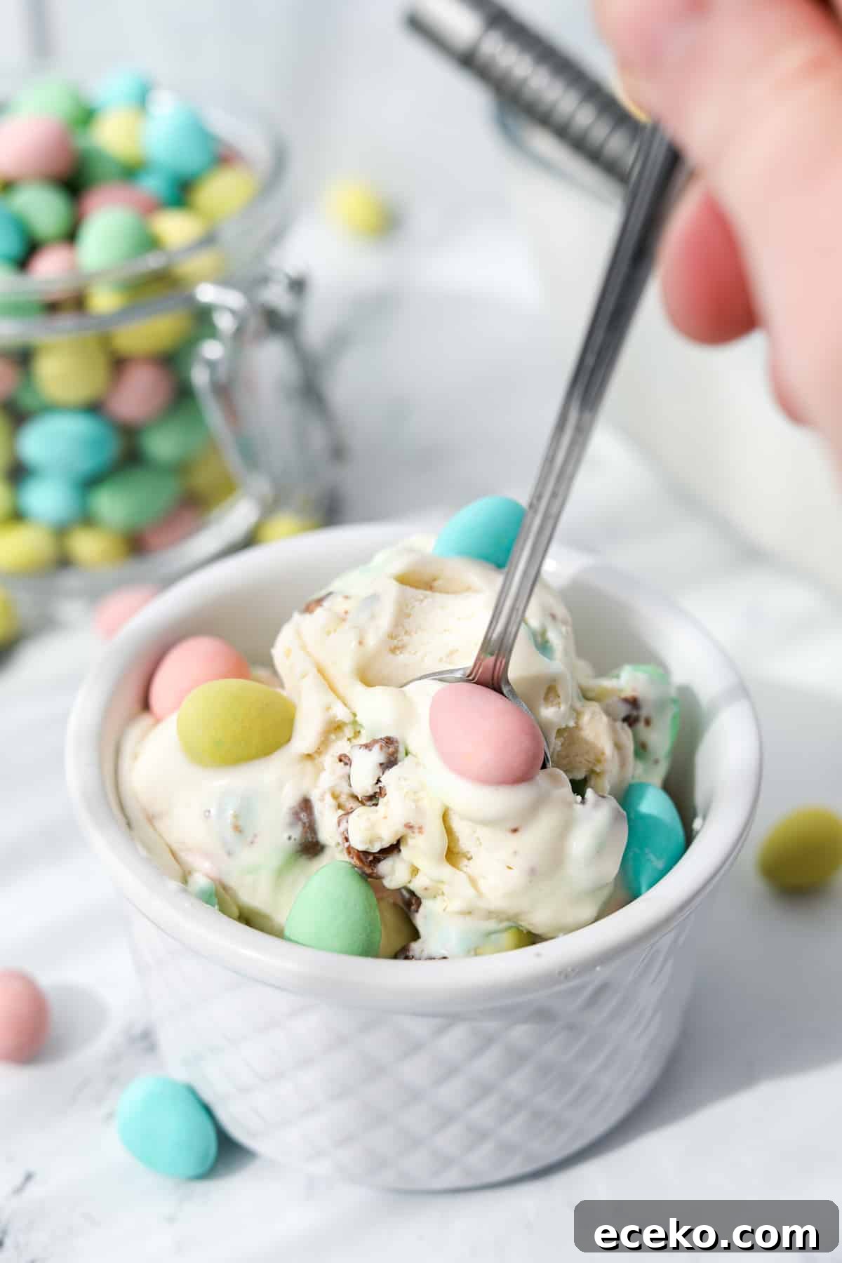 Using a spoon to take a portion of homemade mini egg ice cream from a bowl.