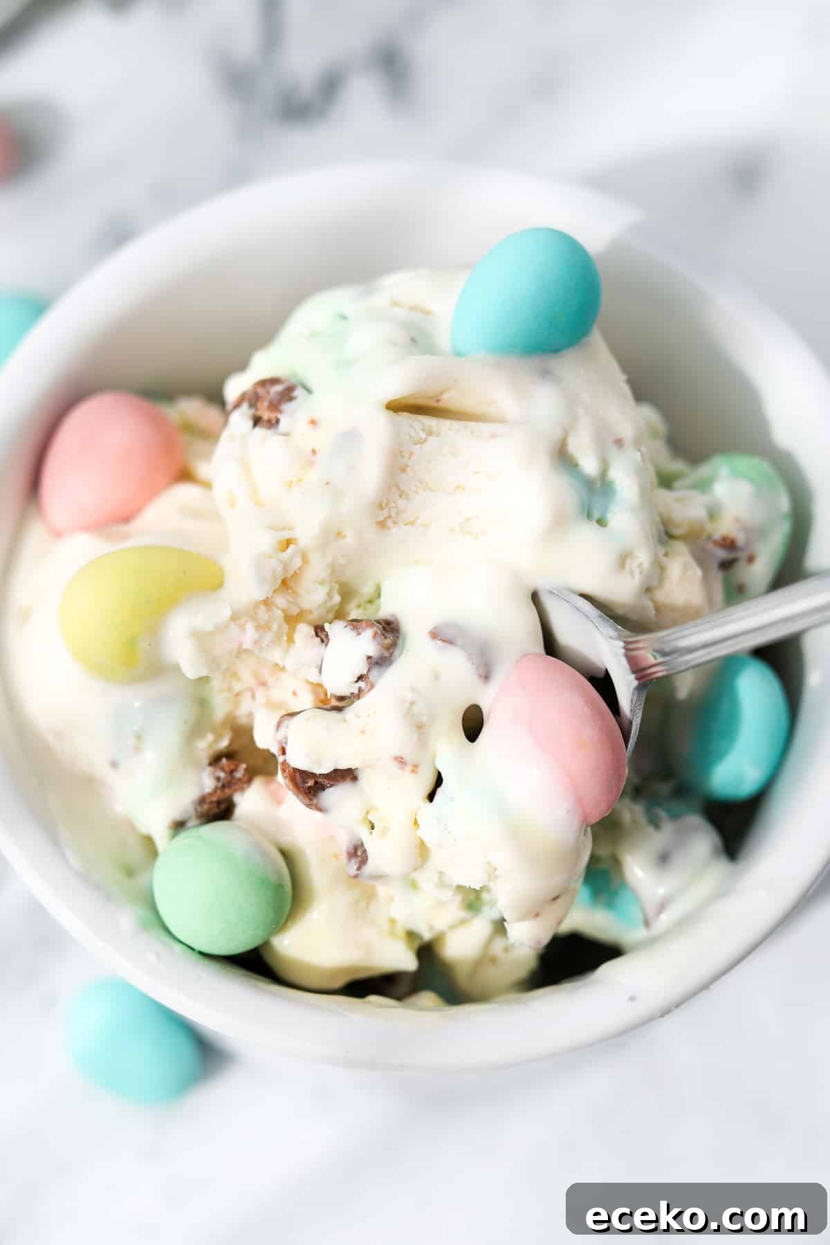 A spoon inside of a small bowl of ice cream.