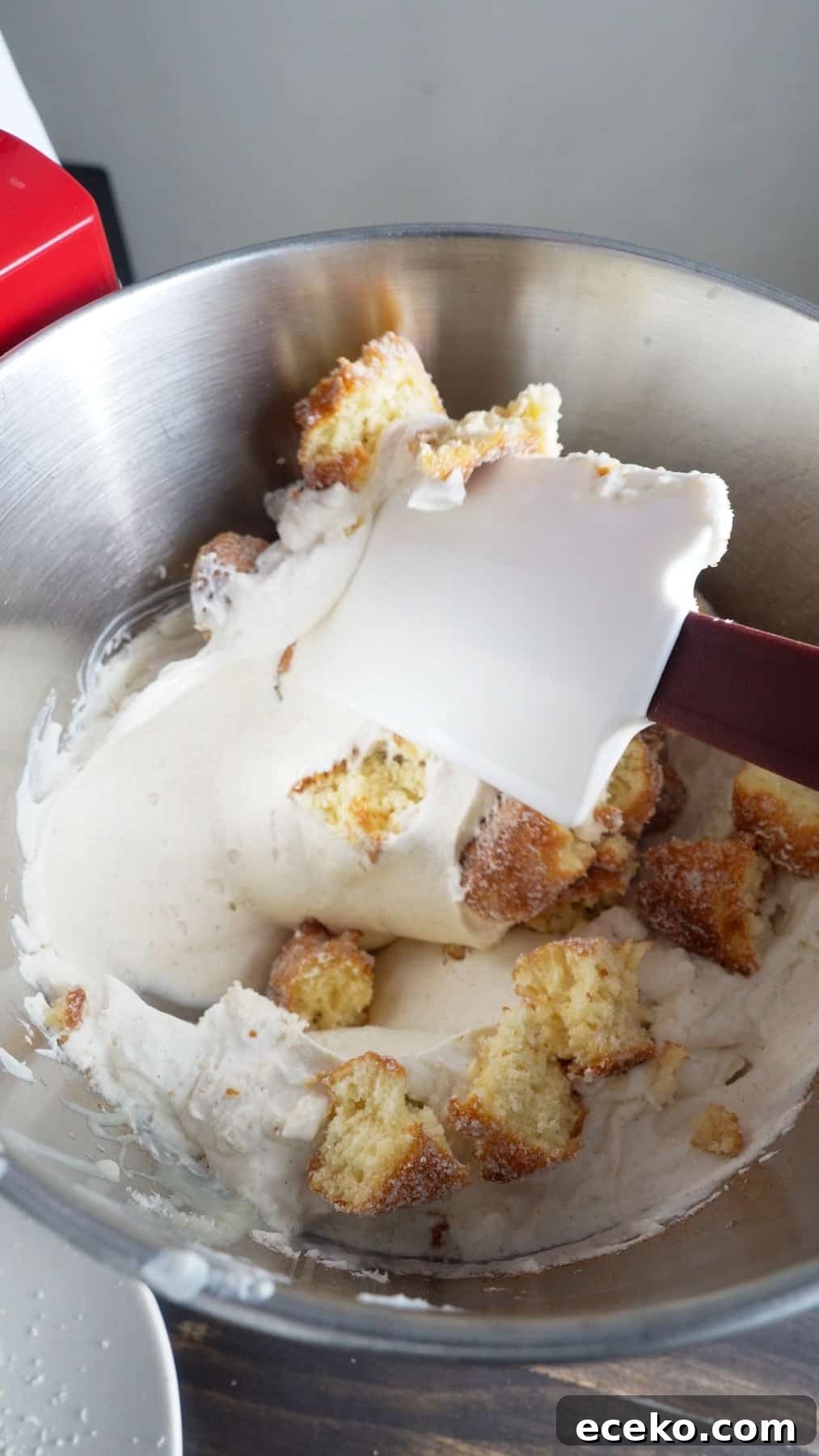 Cider donuts torn into bite size pieces getting stirred into no-churn ice cream base.