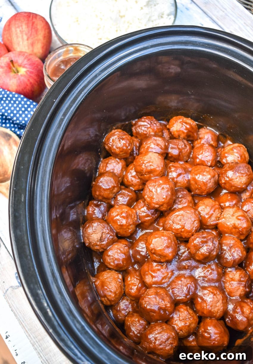 Slow Cooker Apple Butter Meatballs: Sweet Savory Dinner Recipe 4 apple butter meatballs in the black bowl of a slow cooker