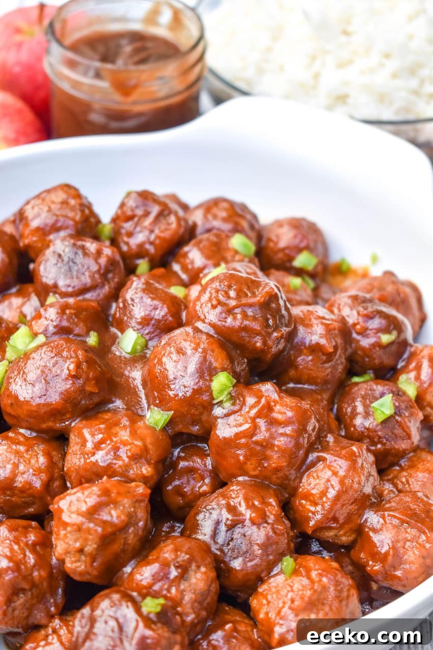 Slow Cooker Apple Butter Meatballs: Sweet Savory Dinner Recipe 7 a close up of crockpot apple butter meatballs in a white serving bowl