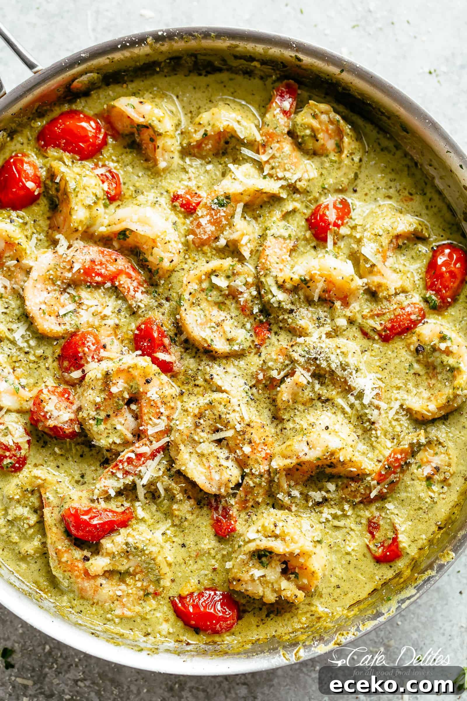 Creamy Pesto Shrimp Alfredo with parmesan cheese and blistered tomatoes is the shrimp recipe of your dreams! Ready in less than 10 minutes, gluten free AND low carb! Serve over zucchini noodles or cauliflower rice 