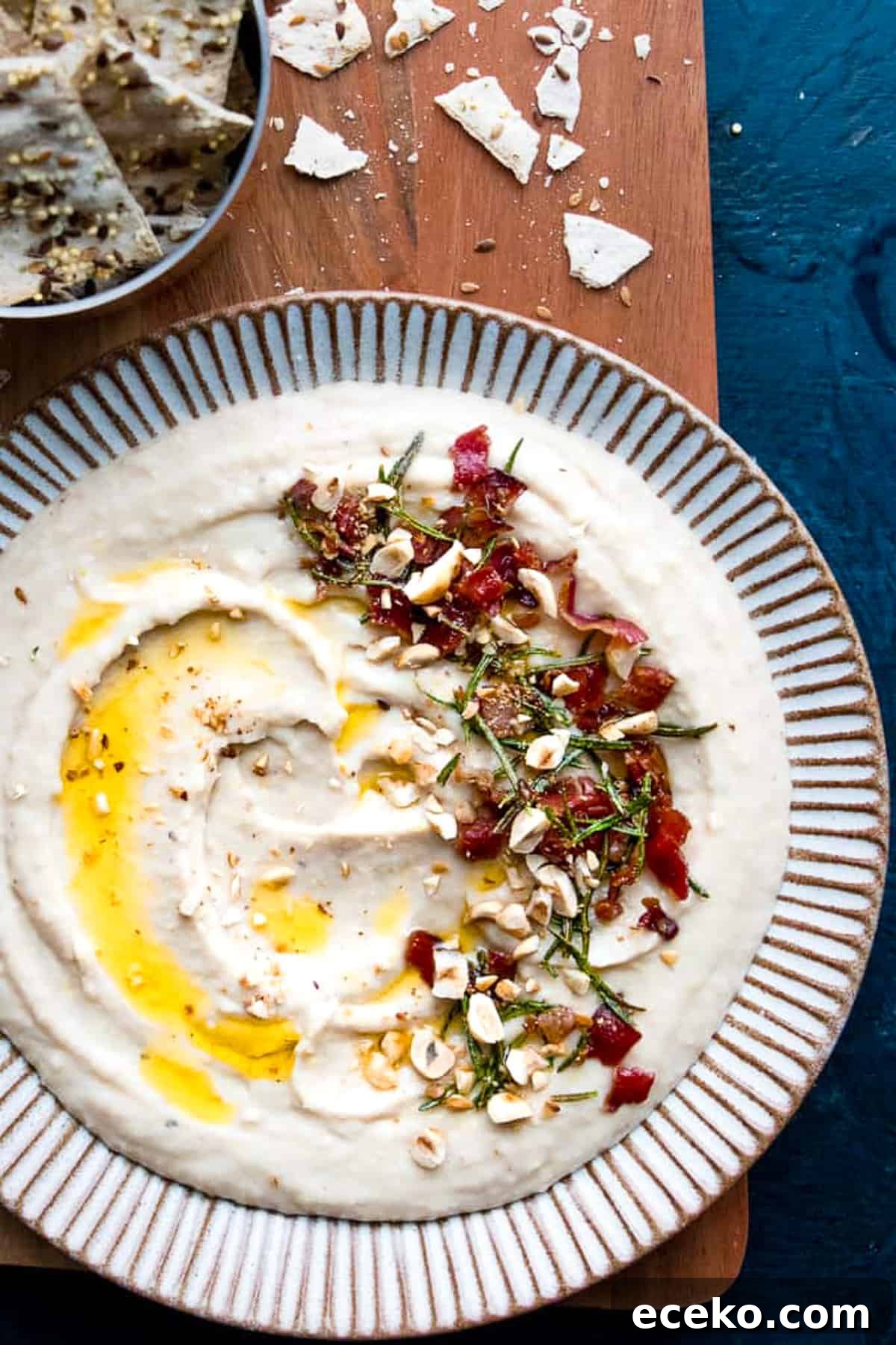 Homemade creamy white bean dip on a plate drizzled with olive oil.