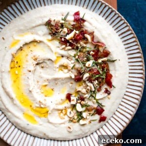 Homemade creamy white bean dip on a plate drizzled with olive oil.