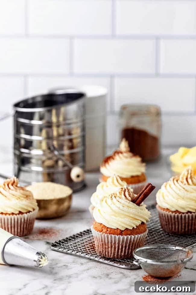 cupcakes on a cooling rack with a piping bag full of frosting