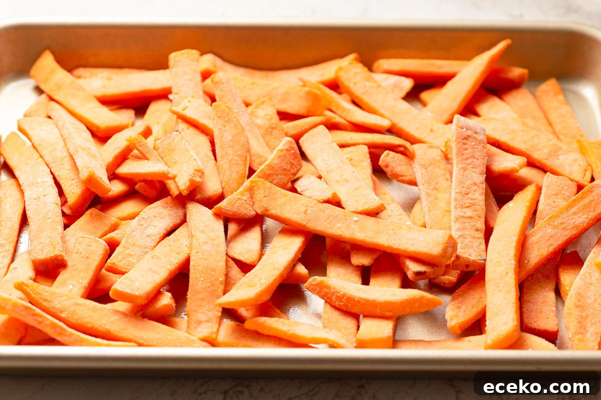 Crispy Frozen Sweet Potato Fries in the Air Fryer 3 frozen sweet potato fries on a baking sheet