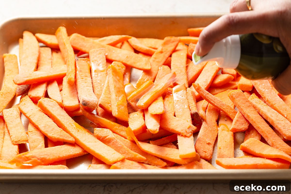 Crispy Frozen Sweet Potato Fries in the Air Fryer 4 spraying the frozen sweet potato fries with an oil mister.