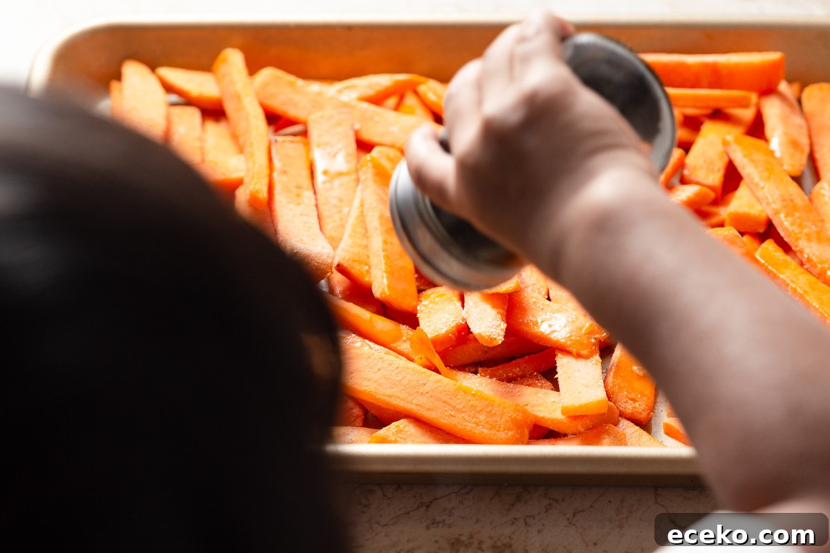 Crispy Frozen Sweet Potato Fries in the Air Fryer 5 seasoning the frozen sweet potato fries.