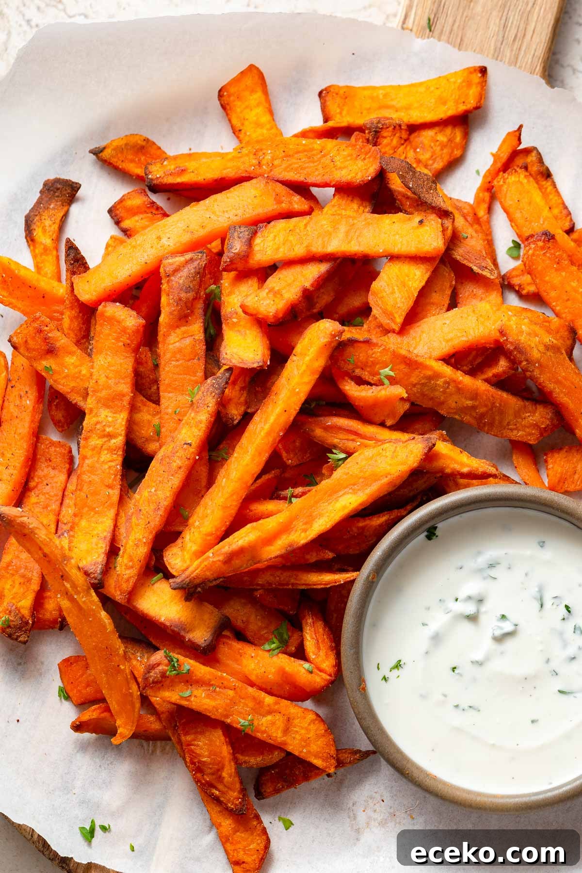 Crispy Frozen Sweet Potato Fries in the Air Fryer 8 frozen sweet potato fries in the air fryer with a dip on the side.