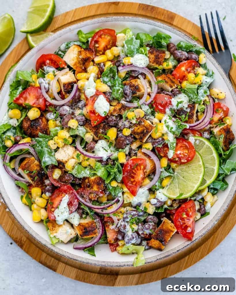 top view chicken chopped salad mixed with dressing and served in a white plate