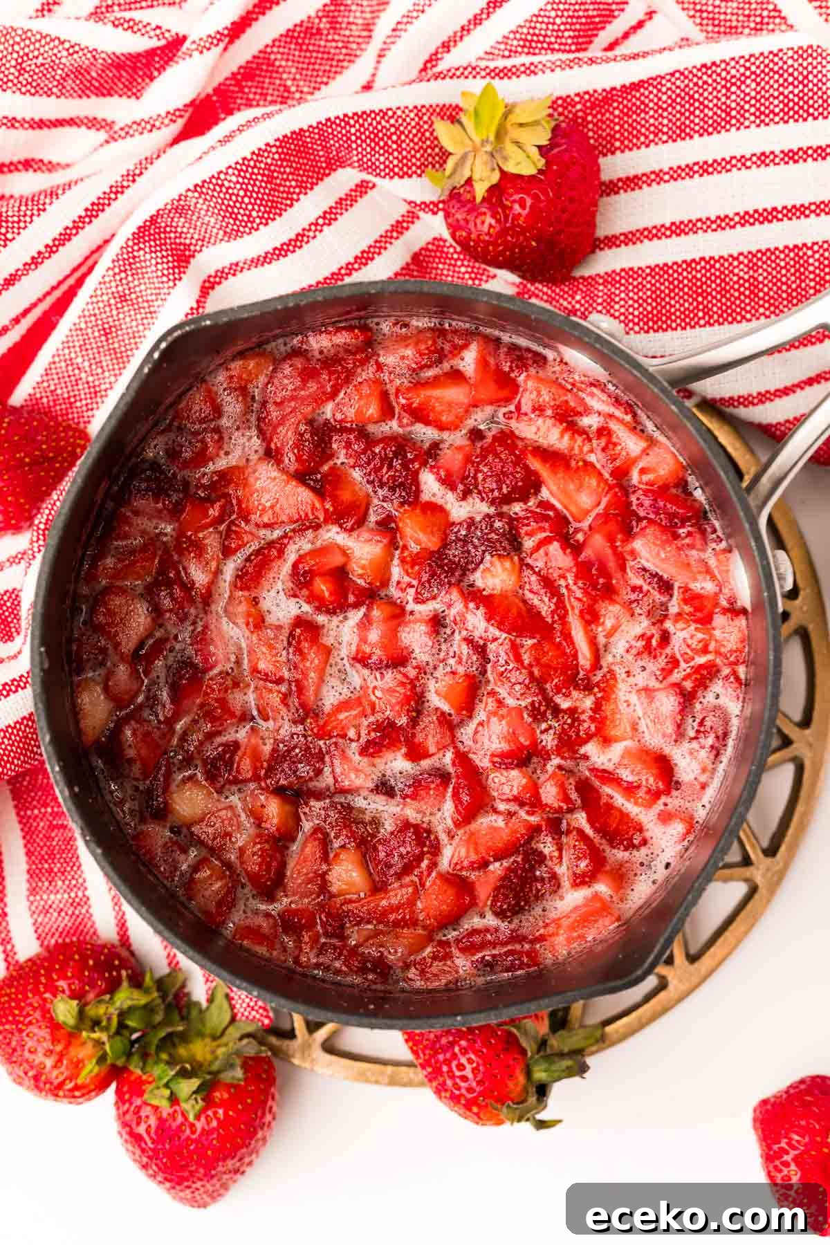 Refreshing Iced Strawberry Tea Recipe for Summer Infusions 5 Overhead photo of a saucepan with strawberries in it to make strawberry simple syrup.