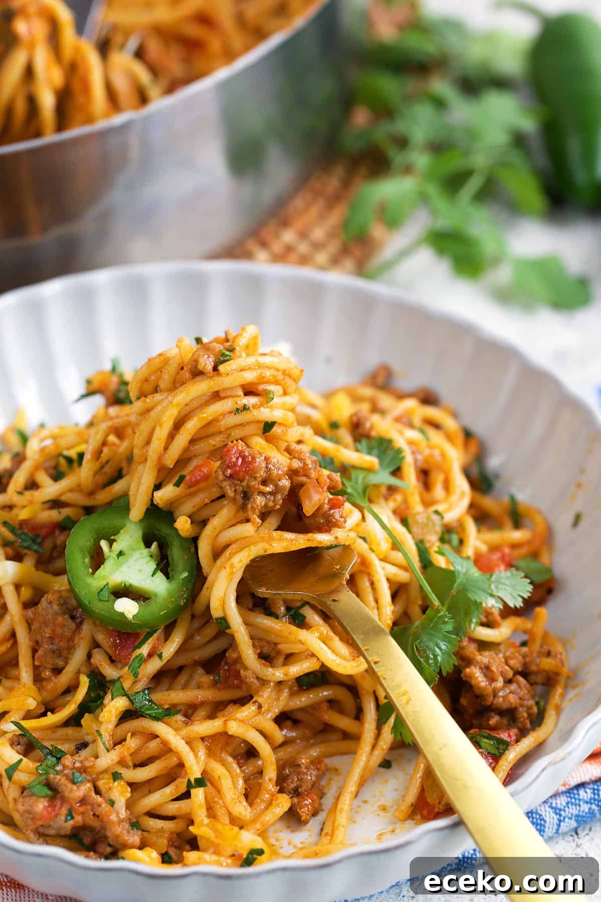 Taco Spaghetti Recipe: Spicy Mexican-Italian Fusion Pasta 6 Taco Spaghetti twirled around a gold fork in a white bowl