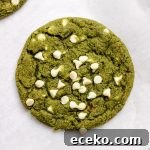 Matcha cookies with white chocolate chips on parchment paper.