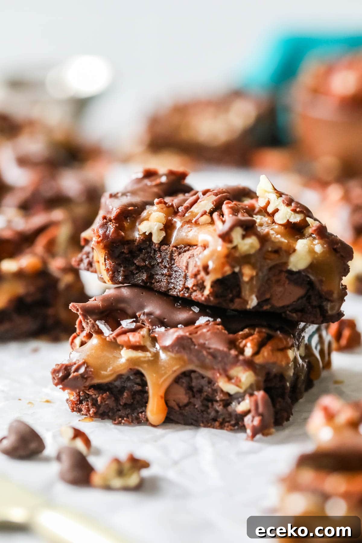 Two turtle brownies stacked on top of each other with the top brownie missing a bite.
