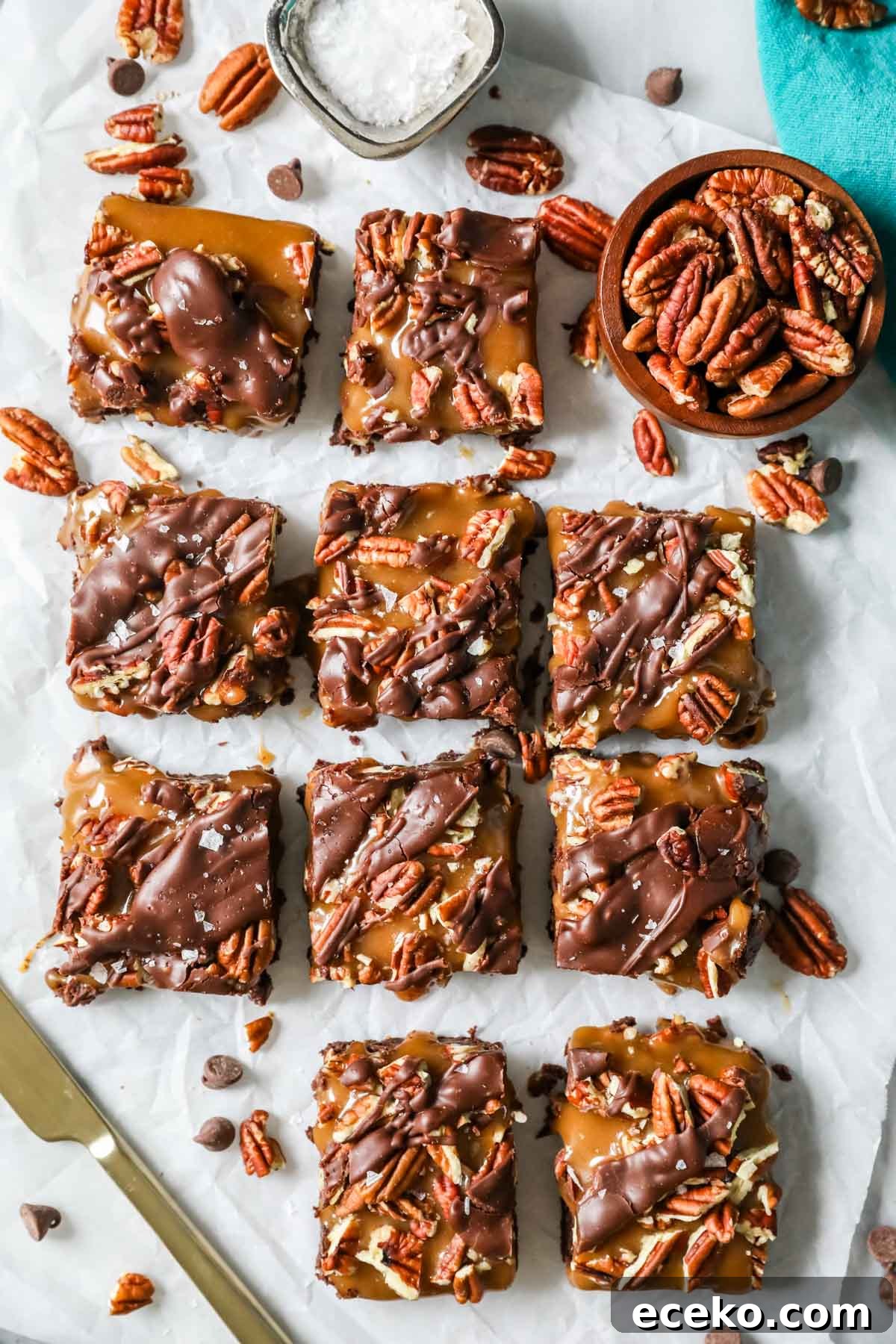 Overhead view of brownies topped with caramel and pecans.