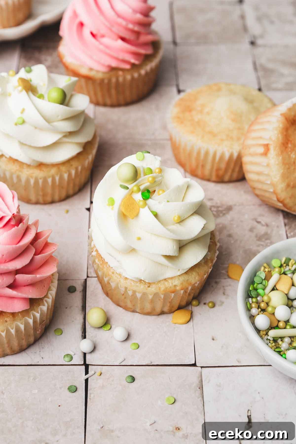 oil vanilla cupcakes topped with frosting on a table
