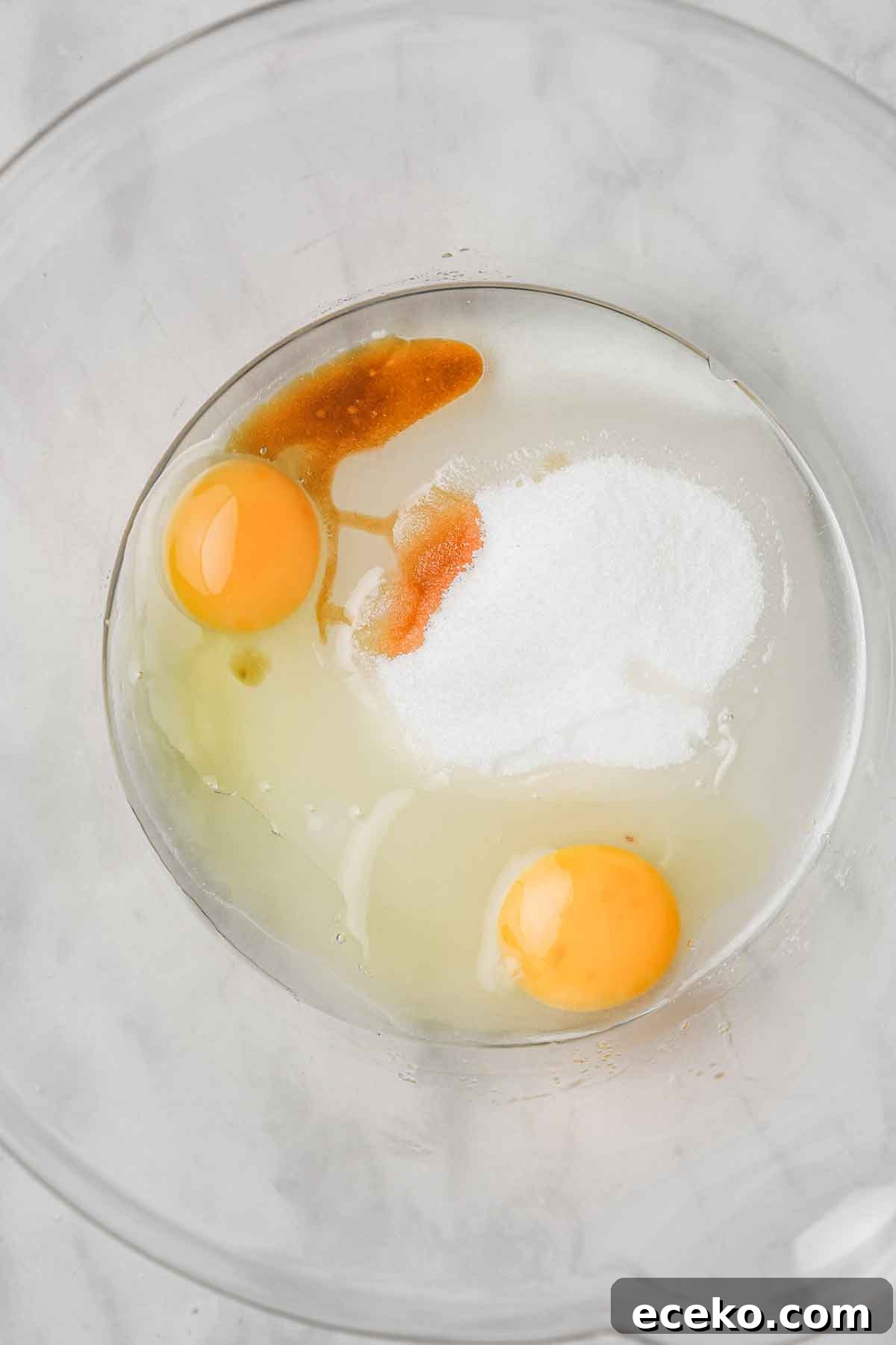 large mixing bowl with oil-based vanilla cupcake ingredients