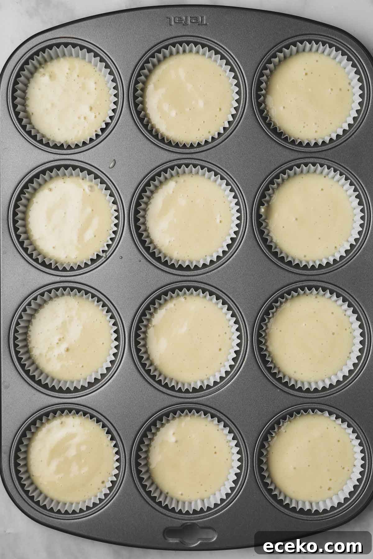 muffin pan filled with vanilla cupcake batter
