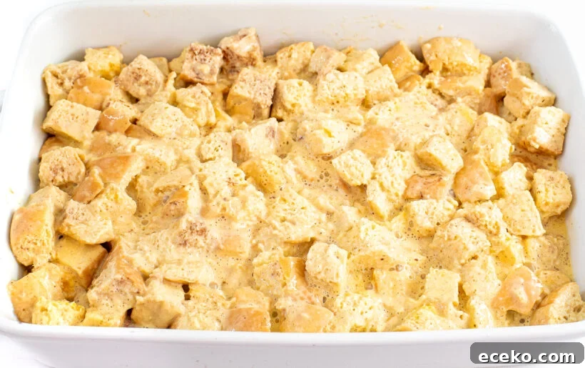 Unbaked eggnog casserole in a white baking dish.