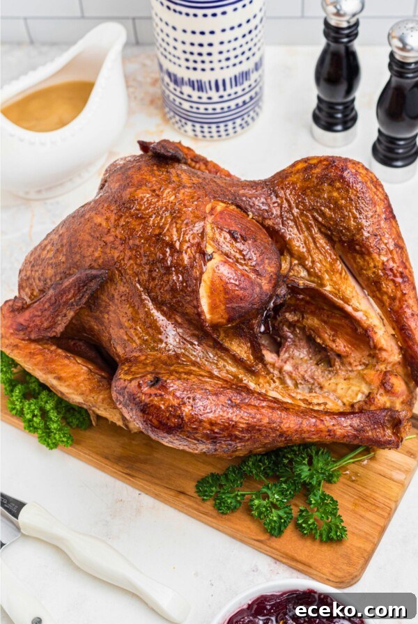 Golden smoked turkey on a brown wooden cutting board, with parsley next to it as a garnish.