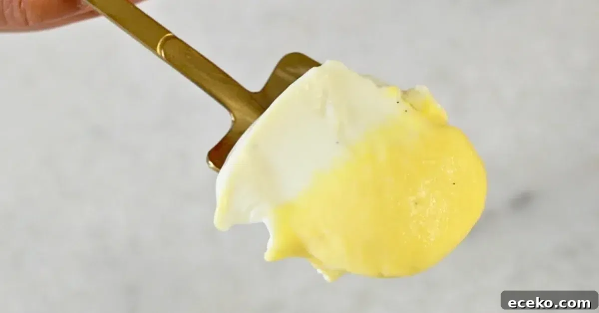 layers of vanilla panna cotta and mango panna cotta in a spoon