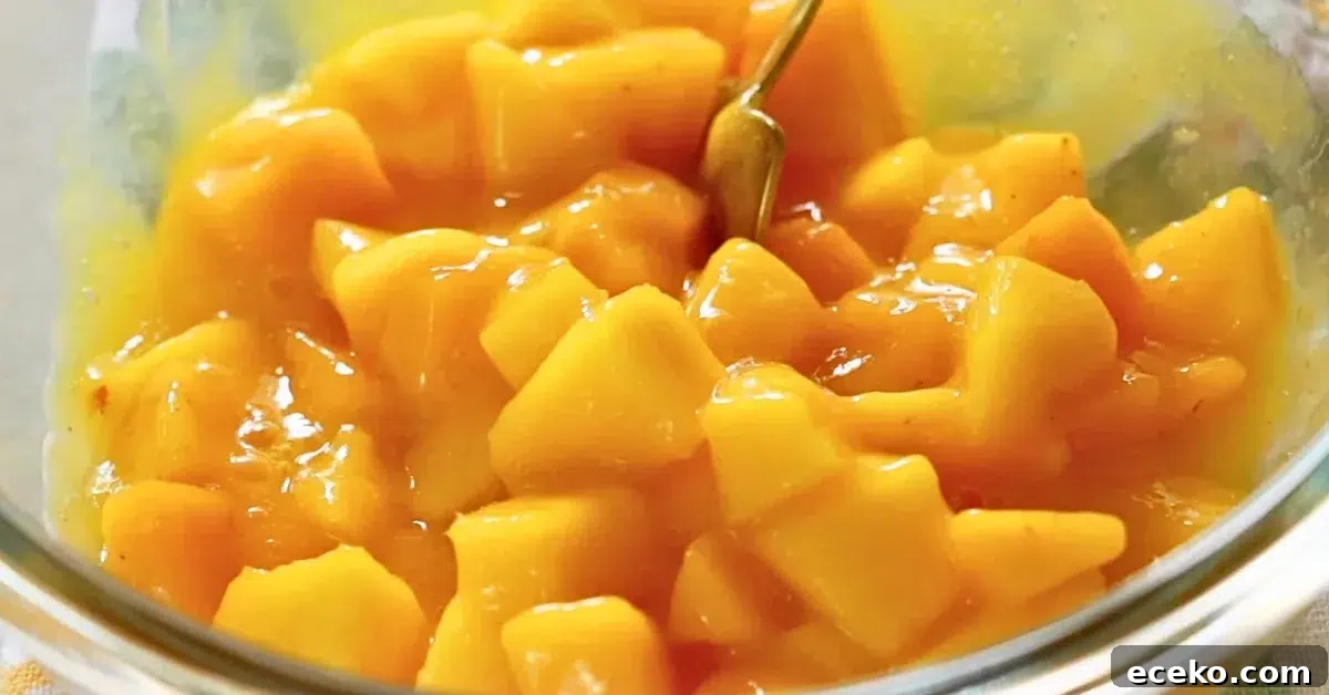 mixing fresh mango and pureed mango in a bowl