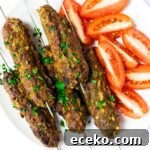 A top down view of a plate of beef kofta kebabs.