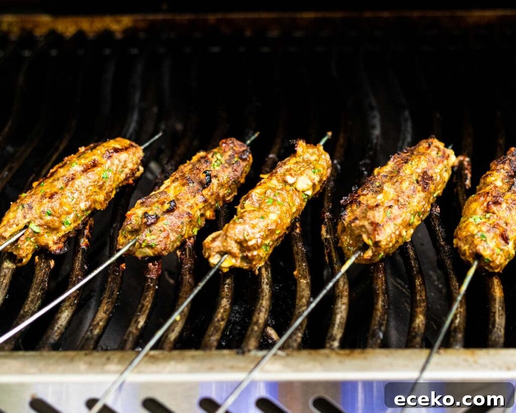 beef kofta kebabs cooking on a grill.