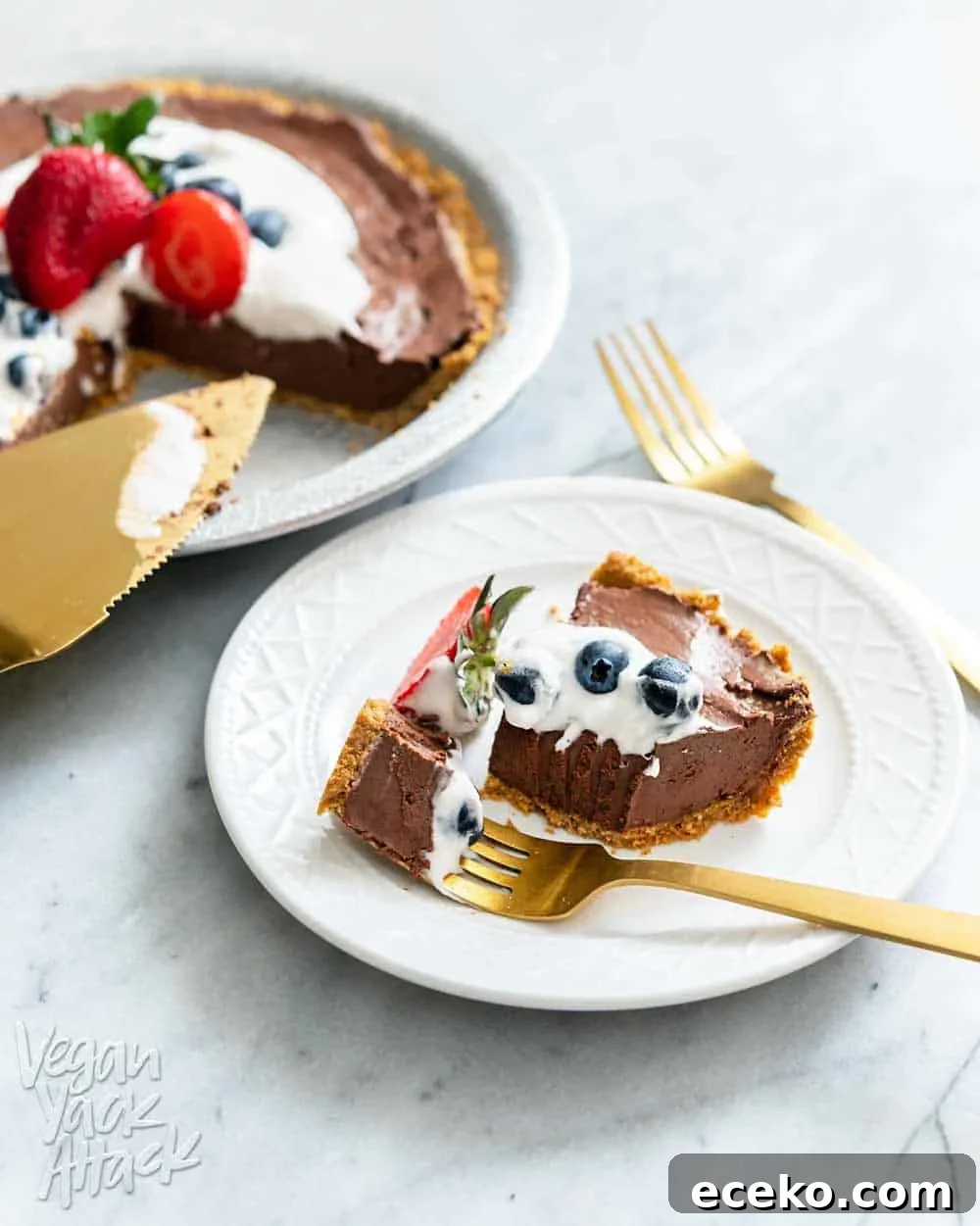 Slice of chocolate pie on a plate next to whole pie and gold pie server