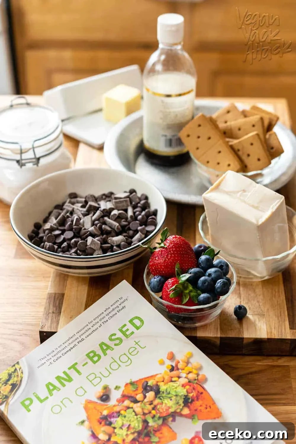 Ingredients for vegan dessert laid out on cutting board, plus the Plant-Based on a Budget cookbook