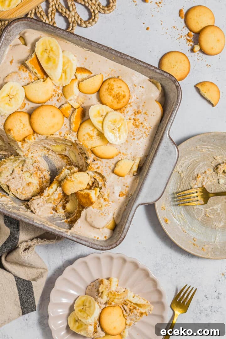 Dairy-free banana pudding in a baking dish, being scooped onto a serving plate.
