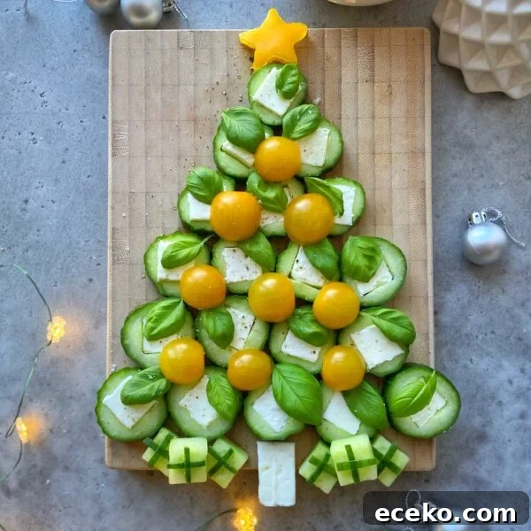 Festive Holiday Appetizers for Entertaining Guests 10 Festive and healthy, this Christmas tree is crafted from cucumber slices, basil, yellow cherry tomatoes, and cheese bites on a wooden board, with little cheese and cucumber presents and a yellow star on top—perfect for holiday food recipes!.