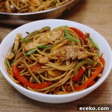 chicken stir fry with noodles in a white bowl.
