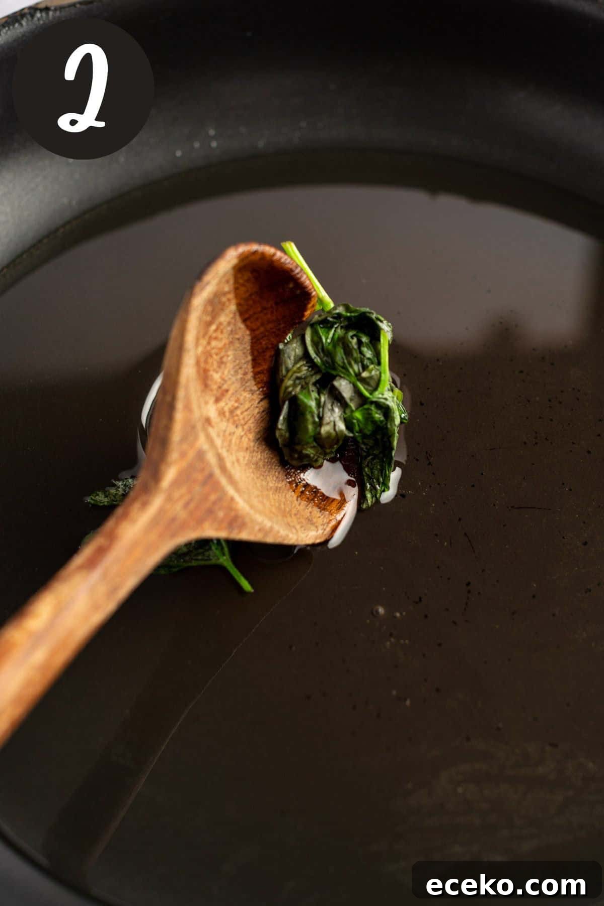 Straining out the basil leaves from the syrup.