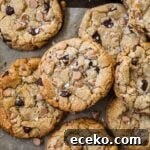 Butterscotch chocolate chip cookies with flaky sea salt on a baking sheet lined with parchment paper.