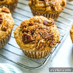 A batch of banana pecan muffins on a baking rack topped with a pecan streusel topping.