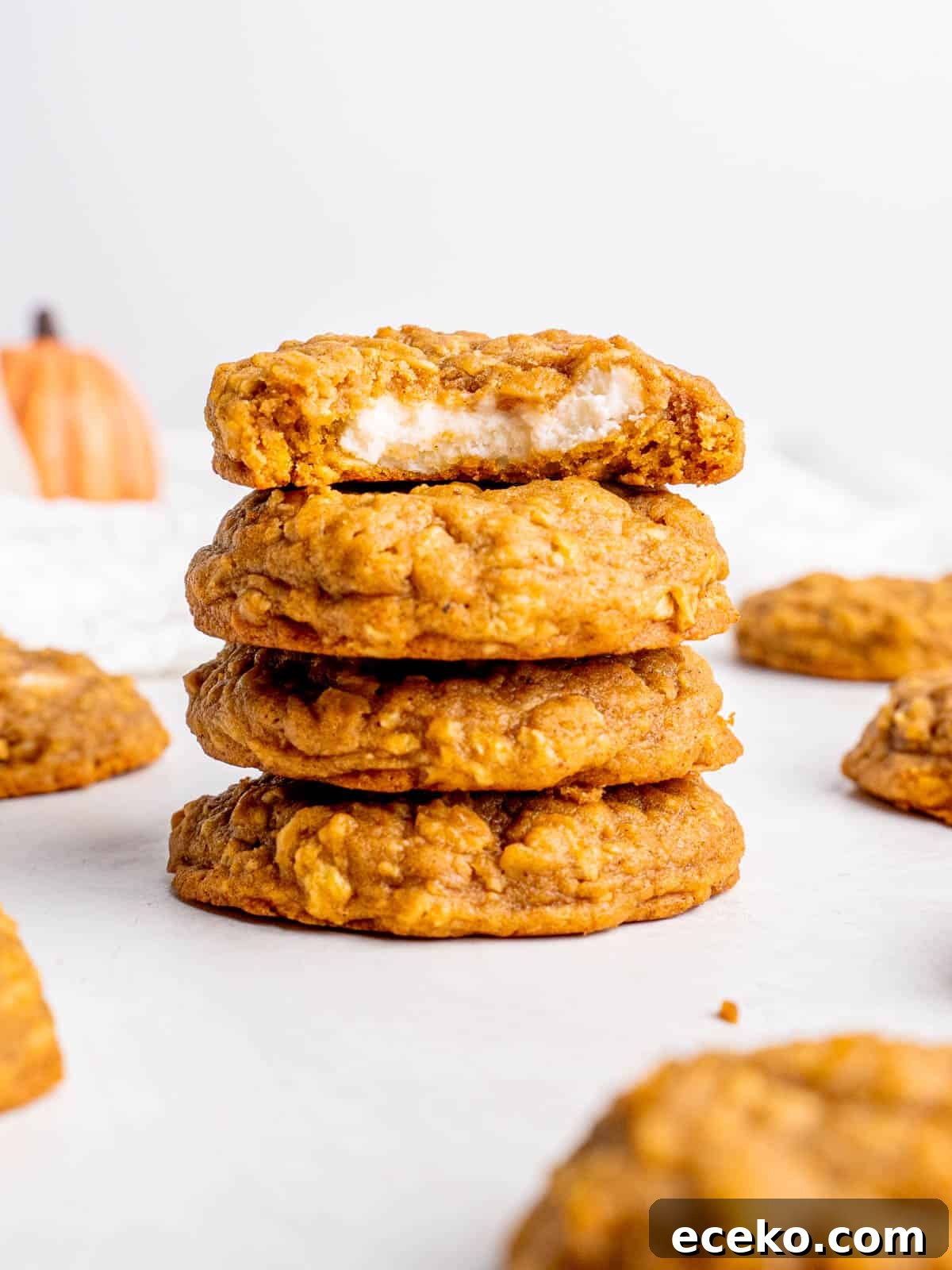 Oatmeal Pumpkin Cheesecake Cookie Recipe for Fall Baking 2 a stack of oatmeal pumpkin cheesecake cookies with the top one cut in half revealing the filling