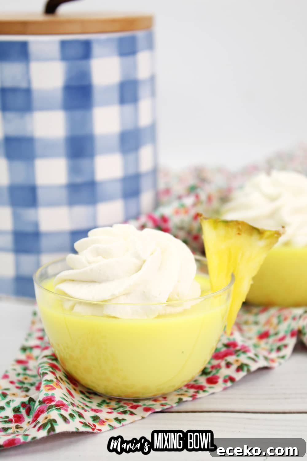 Dole Whip Shot Recipe: How to Make the Creamy Tropical Cocktail 3 dole whip shot in a small glass bowl garnished with a slice of pineapple