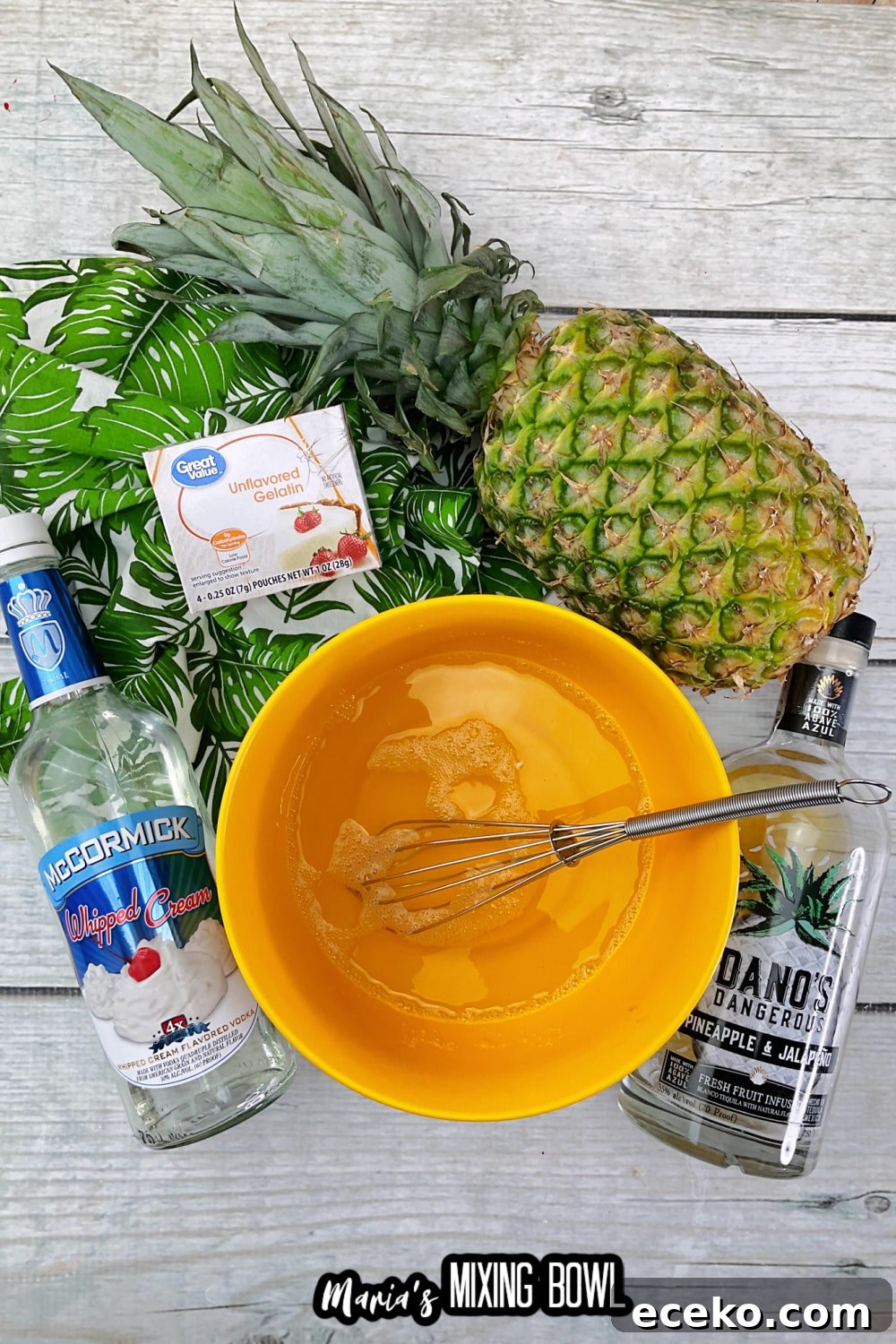Dole Whip Shot Recipe: How to Make the Creamy Tropical Cocktail 4 unflavored gelatin being mixed with water in an orange mixing bowl with a whisk