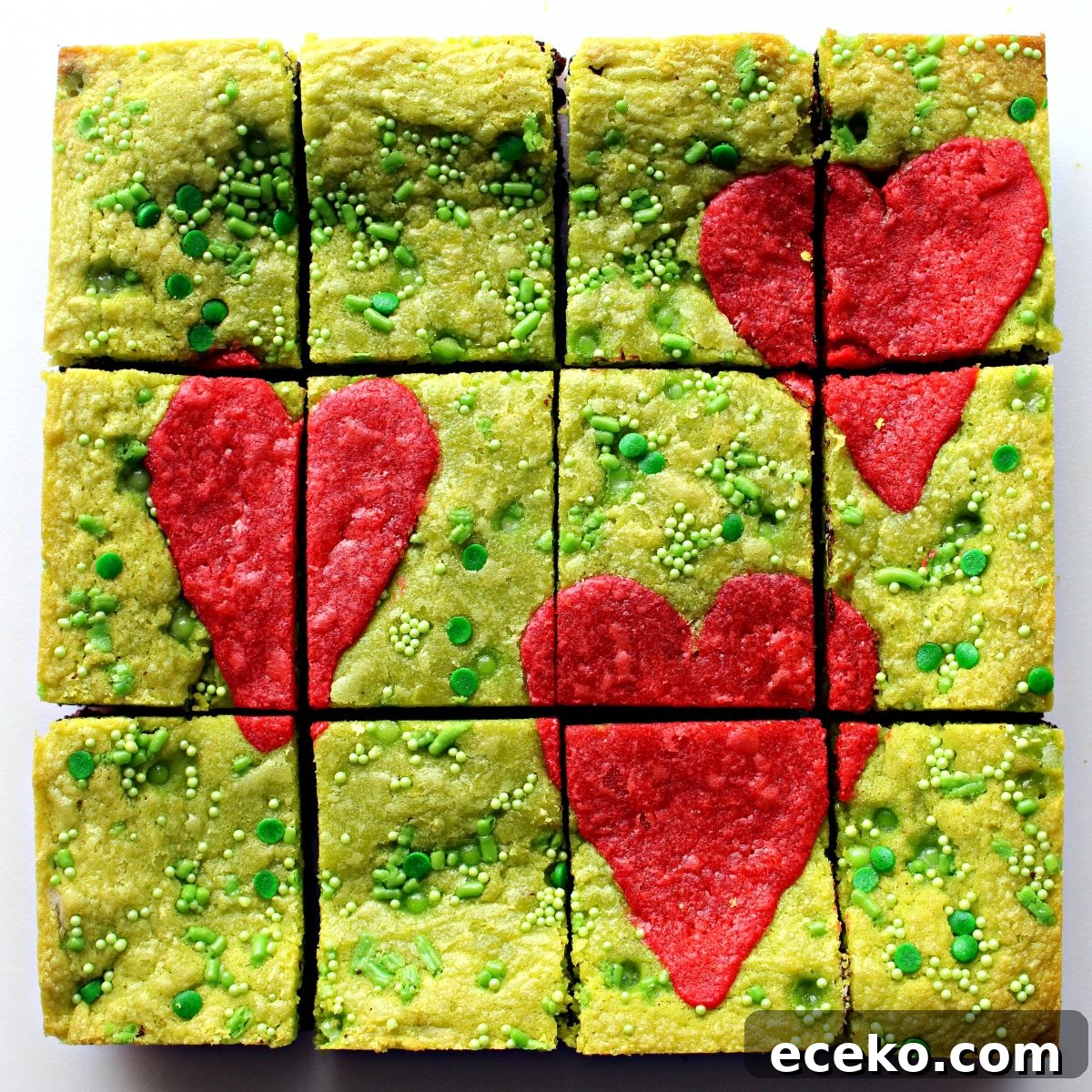 Pan of  green Grinch Brownies with three large hearts on top cut into 12 bars.