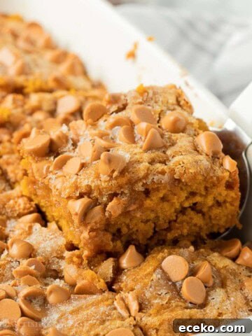 Slice of butterscotch pumpkin cake in pan with spatula.