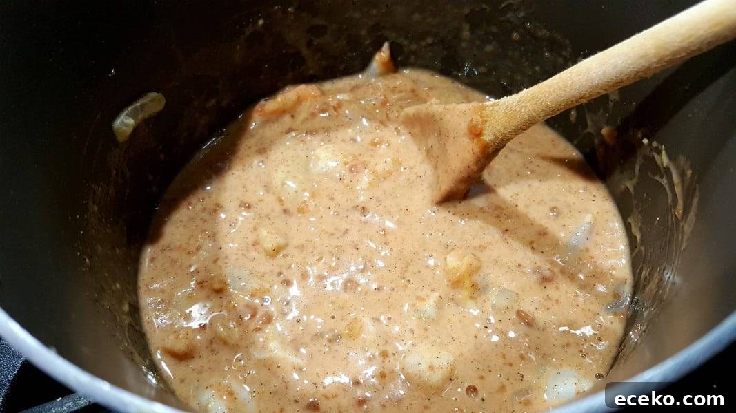 Creamy Shrimp Korma Recipe with Aromatic Spices 6 korma coconut milk sauce cooking in a pan.