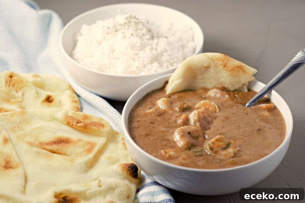 Creamy Shrimp Korma Recipe with Aromatic Spices 7 a bowl of Shrimp Korma, rice, and naan bread.