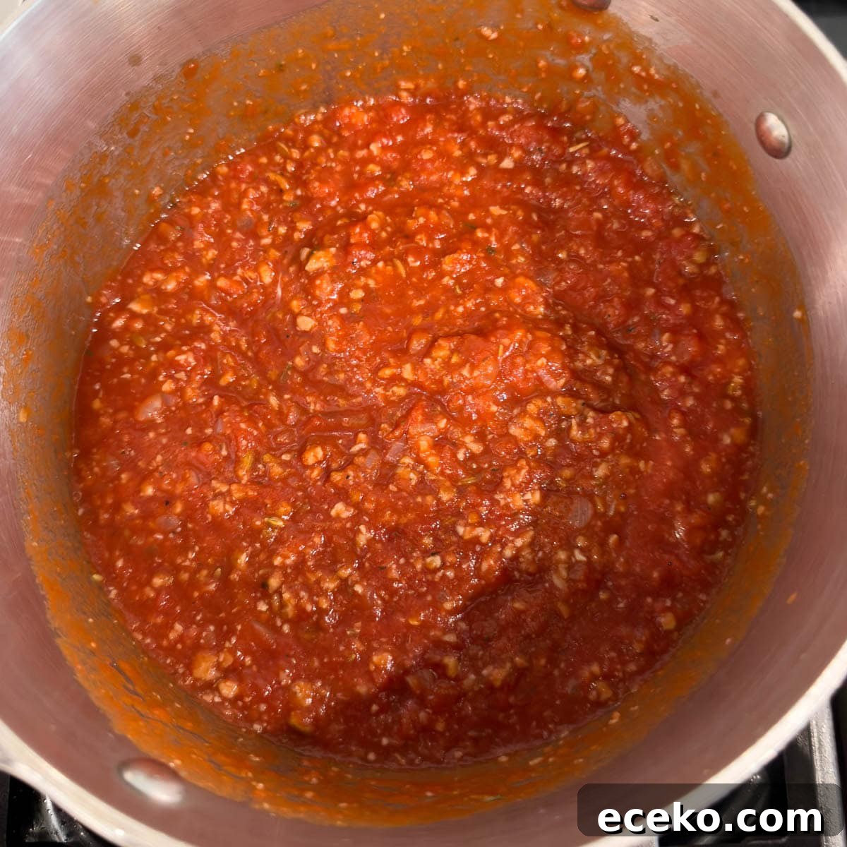 Bright red lasagna sauce with tomatoes, sausage, onions, and herbs. 
